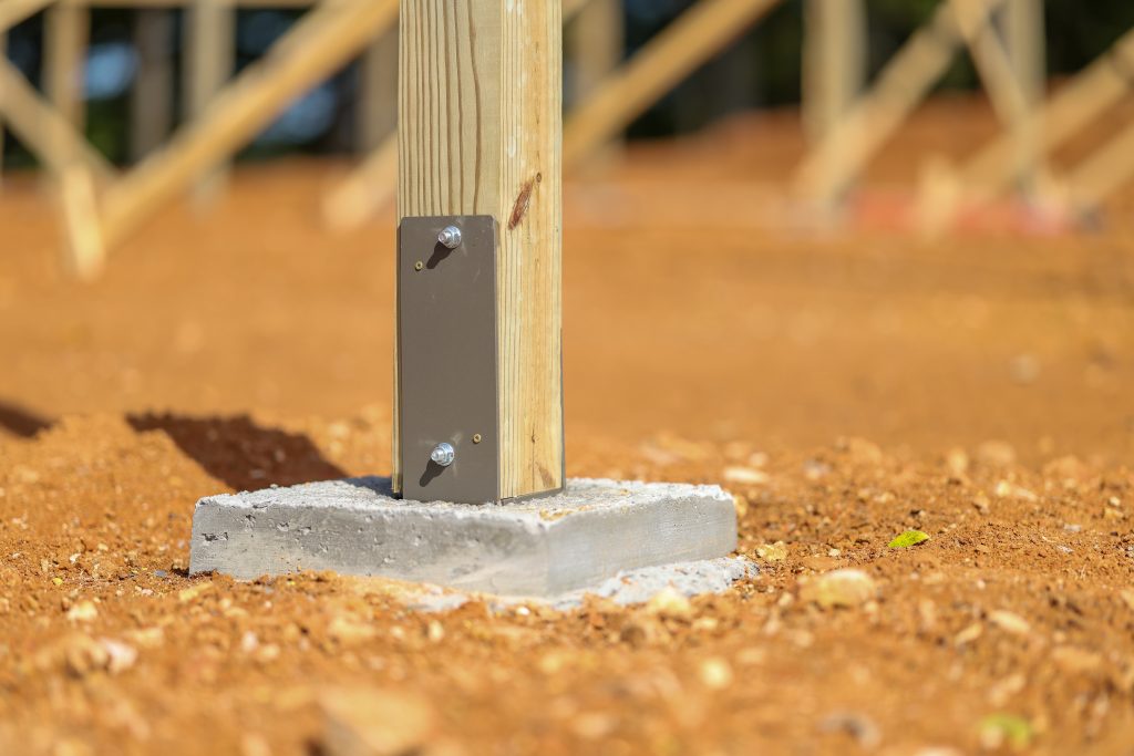 Metal post bracket for pole barn construction.