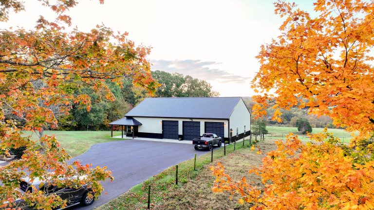 Barndominium built by Triple J Builders with a paved lane and wraparound porch.